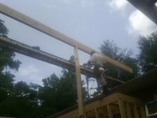 Carpenter setting a ridge beam over a new addition frame — Ice Dam Removal by Roofing Brothers in Weatherly