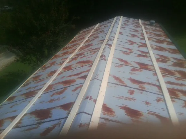Rusted metal roof panels with new wood purlins before replacement — Storm Damage Roof Repair in Weatherly by Roofing Brothers