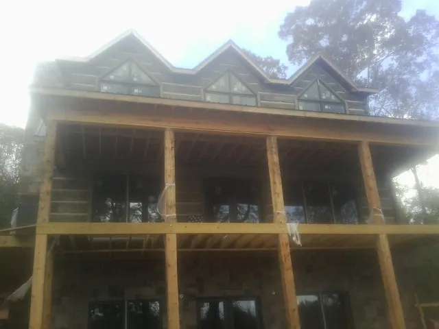 Dormers and porch framing on a large log home under construction — Roof Coating work by our crew in Weatherly