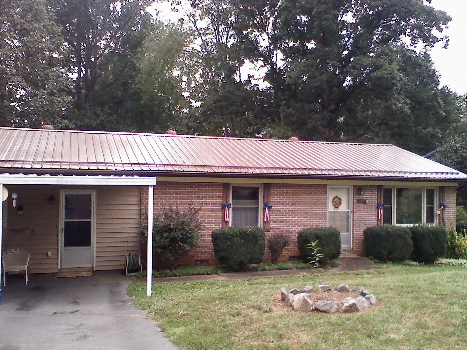 Bronze metal roof and carport on a brick ranch home — Roof Repair work by our crew in Weatherly