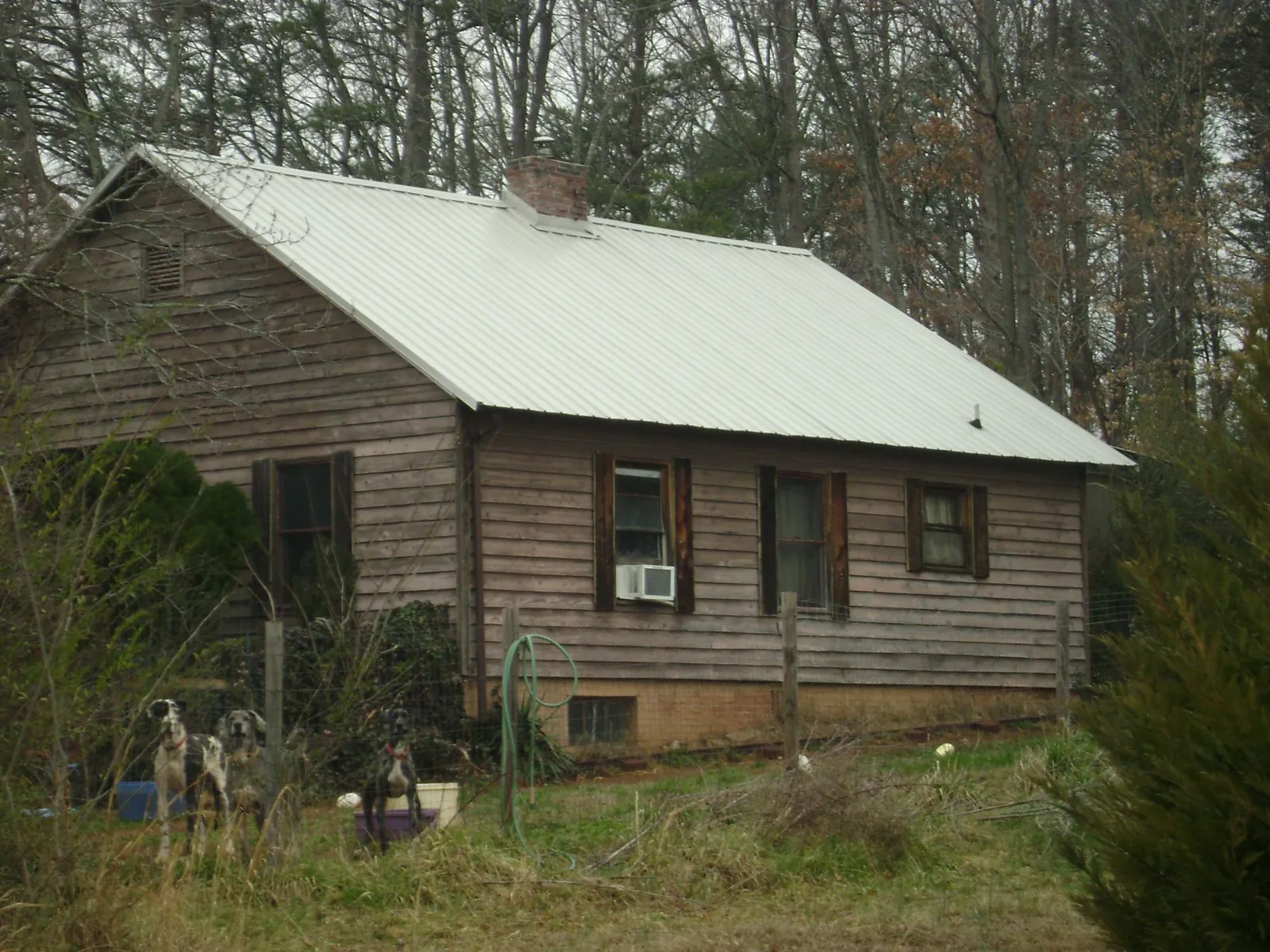 White metal roof on an old wood sided farmhouse, from a Metal Roof Installation job in Weatherly